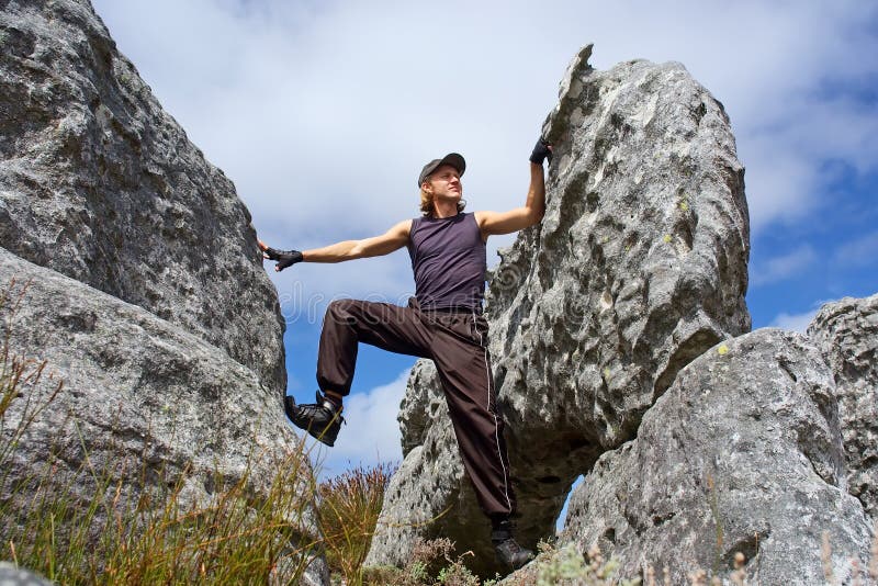 Young man climbs on rock