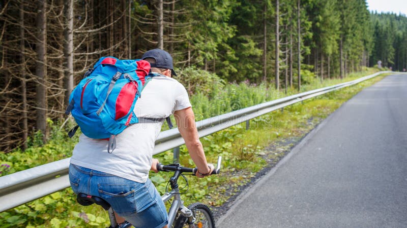 Young man cycling on road in mountains stock image Young man cycling on road in mountains stock image