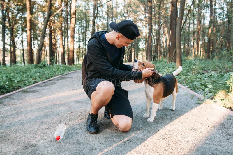 Young man with dog on rural road in forest stock images Young man with dog on rural road in forest stock images