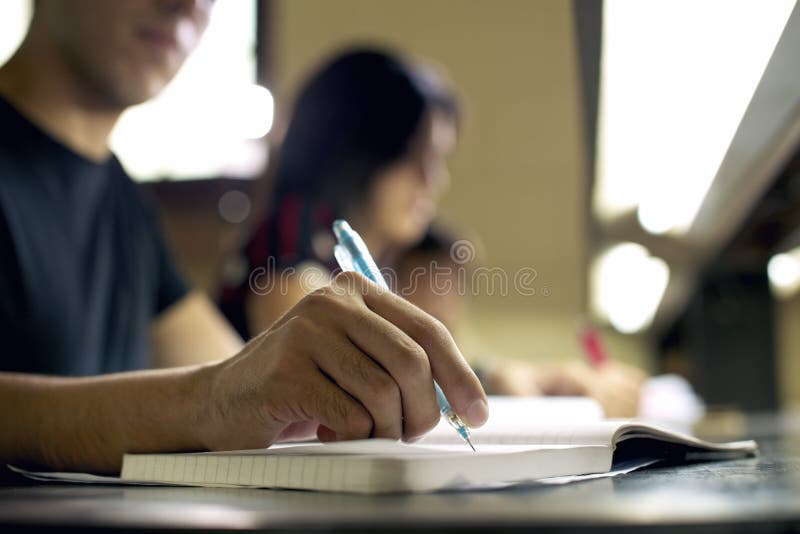 Študenti robenie domácich úloh a pri príprave na skúšky na univerzite, closeup mladých mužov písanie v škole v knižnici.