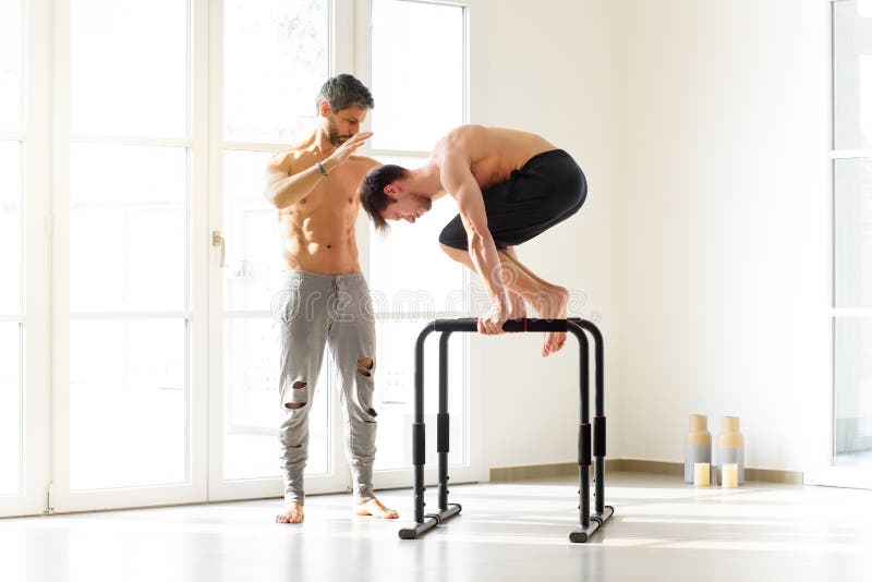 fitness, sport, training, calisthenics and lifestyle concept - Young man  training on the street doing straddle planche Stock Photo
