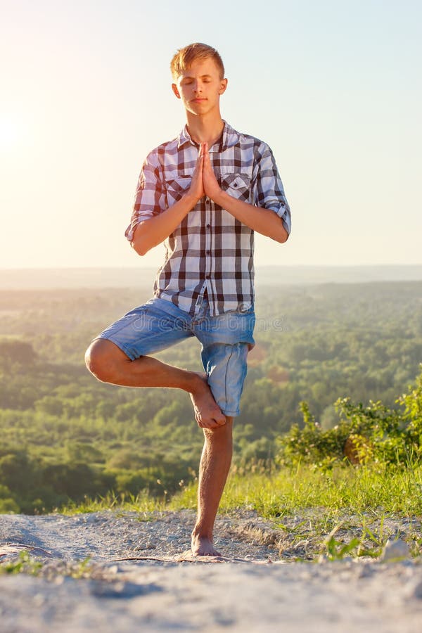Young Man Doing Yoga Outdoors in the Sun Health Concept Stock Photo ...