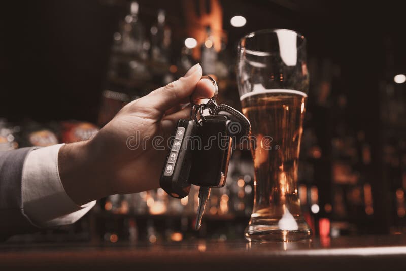 Young Man Drunk with Glass of Beer and Key in His Hand Stock Photo