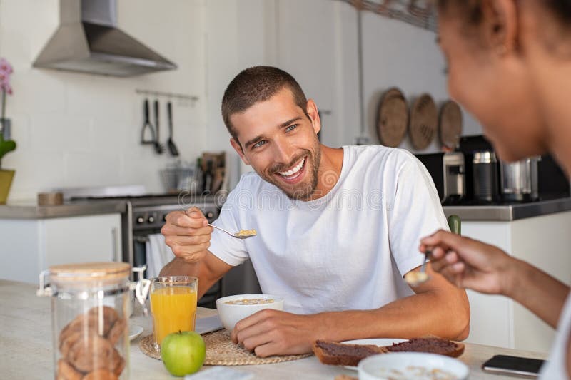 Young man eating cereal at breakfast