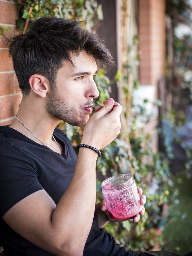 Young man eating ice cream on terrace