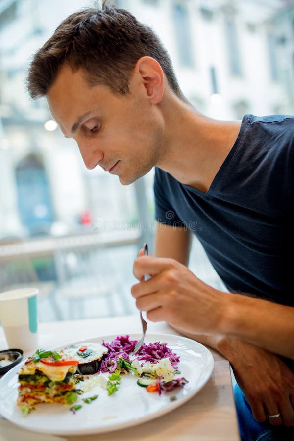 Young man eating salad in a cafe stock photos Young man eating salad in a cafe stock photos