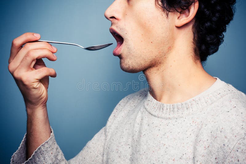 Young Man Eating from a Spoon Stock Image Image of health, person