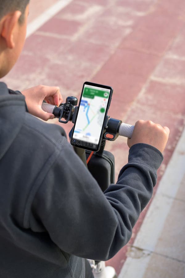 Young Man on an Electric Scooter Using Smartphone Gps Applications
