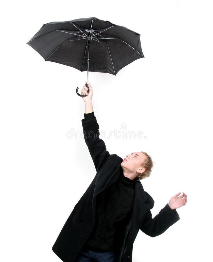 Young man flying away with umbrella