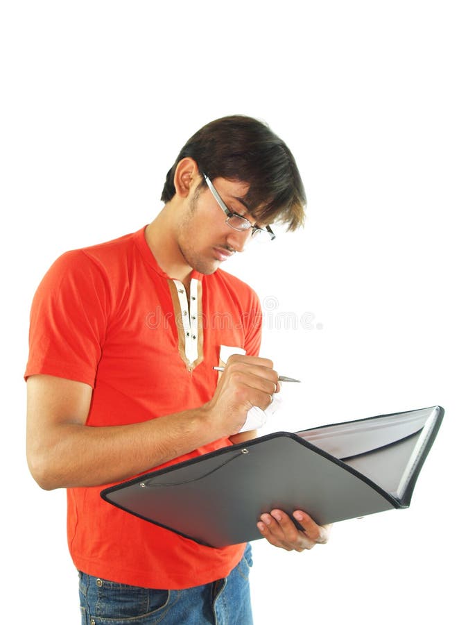 A casually dressed young man making notes in the folder he is holding, isolated on white background. A casually dressed young man making notes in the folder he is holding, isolated on white background.