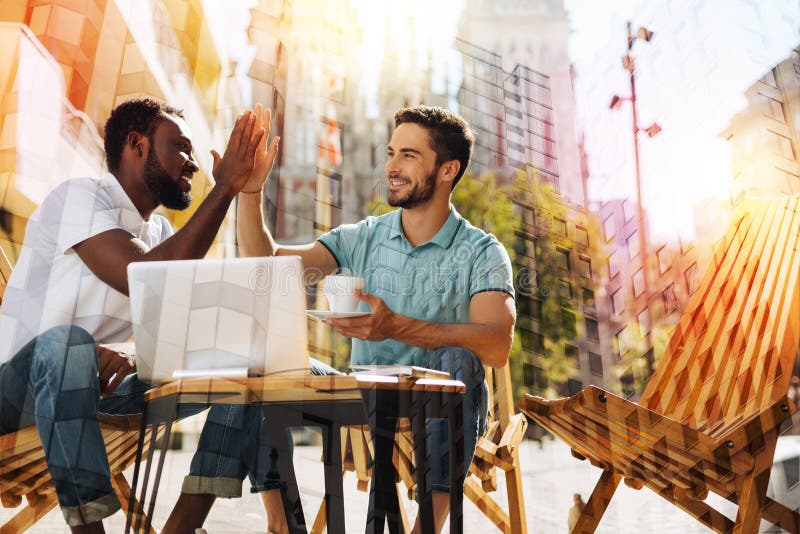 Young man giving five to his friend and feeling proud of him