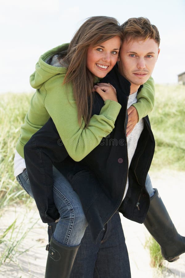 Young Man Giving Woman Piggyback In Dunes