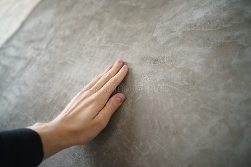 Young man hand touching concrete wall stock photo