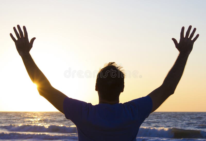 Young man hands up sunrise background blue sky and sea stock photos Young man hands up sunrise background blue sky and sea stock photos