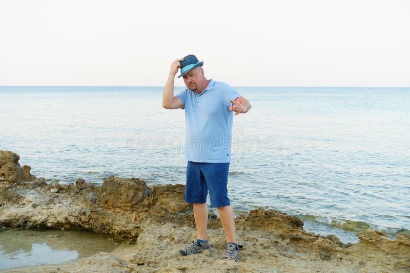Young man in hat posing on the seashore stock photos