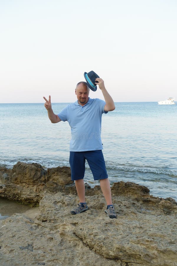 Young man in hat posing on the seashore stock photography