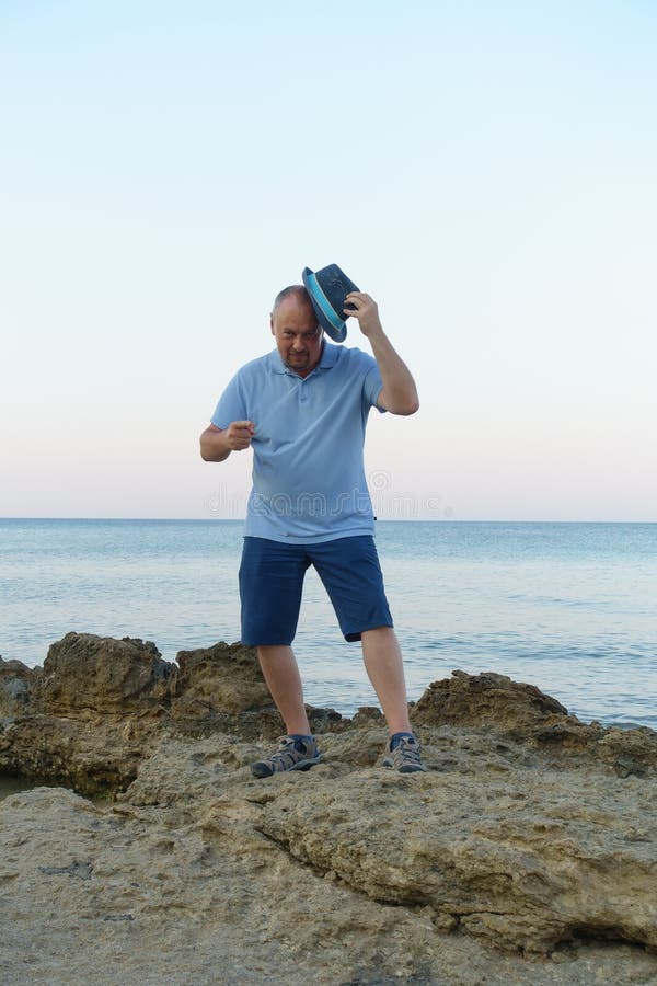 Young man in hat posing on the seashore royalty free stock photos