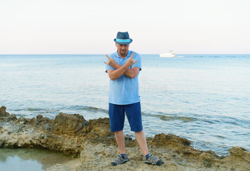 Young man in hat posing on the seashore royalty free stock image