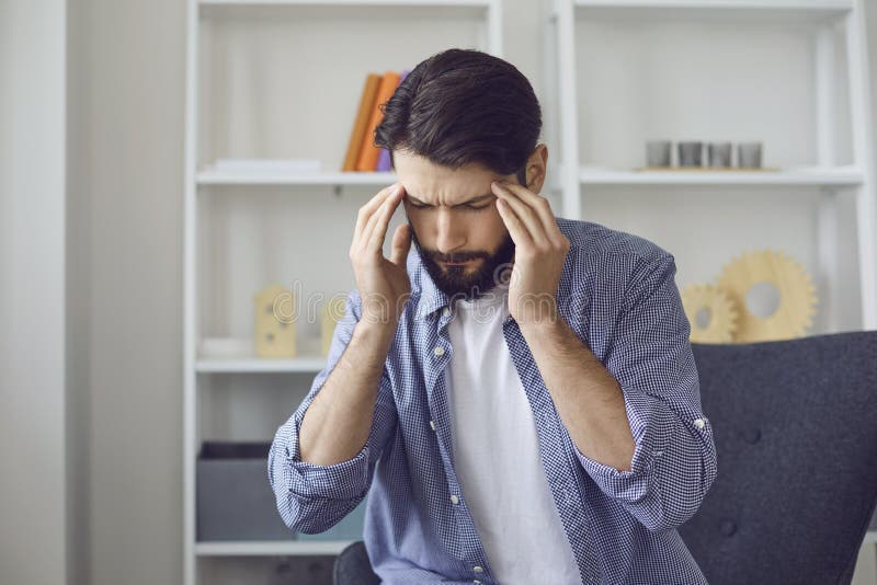 Young man with headache or high blood pressure at home. stock photography Young man with headache or high blood pressure at home. stock photography