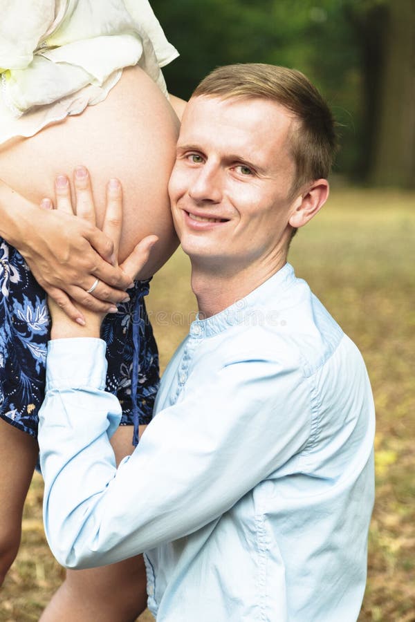 Four Arms Show Heart on Stomach of Pregnant Woman Stock Photo