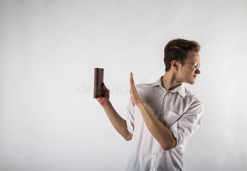 Young man holding workbook in his hands. Dislike and refuse concept