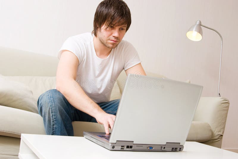 Young man home with laptop