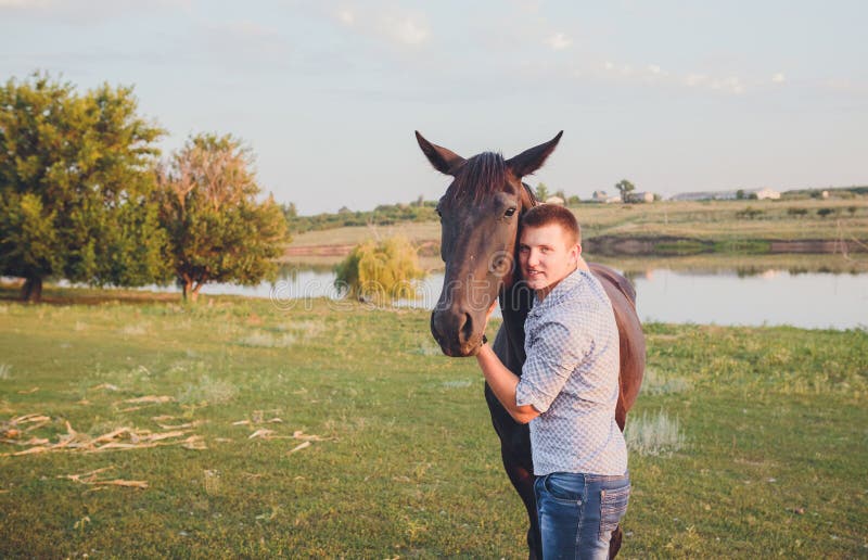 Young man hugs a horse