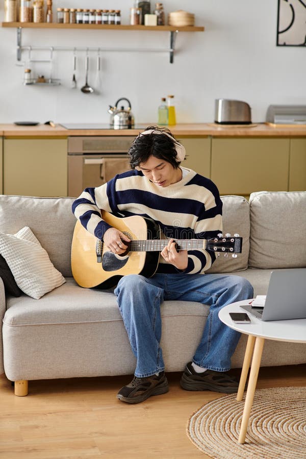 Young man immersed in learning acoustic stock image