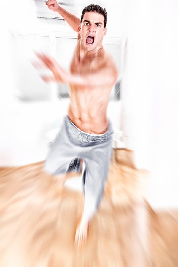 Young man jumping with kicking and clenched fists stock images Young man jumping with kicking and clenched fists stock images