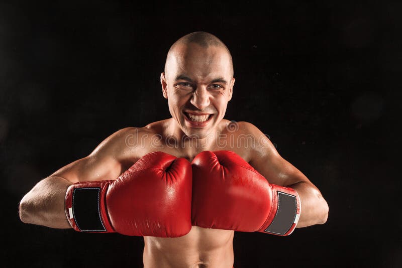 The young man kickboxing on black with screaming face stock photos The young man kickboxing on black with screaming face stock photos