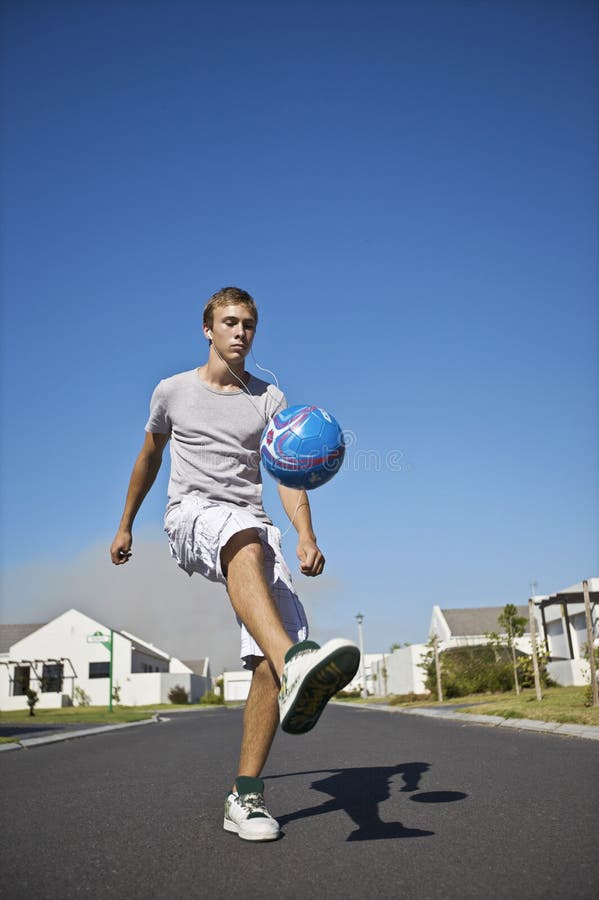 Young Man Kicking Ball on Street Stock Image Image of outdoors