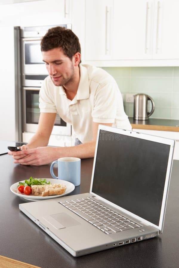 Young Man With Laptop In Kitchen