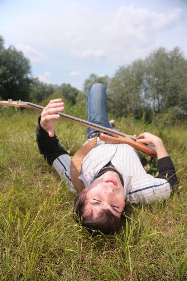 Young man lies with guitar