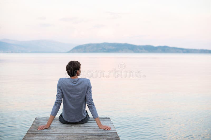 Enjoying life. Back side of young man looking at the sea, vacations  lifestyle, mindfulness, summer fun concept Stock Photo