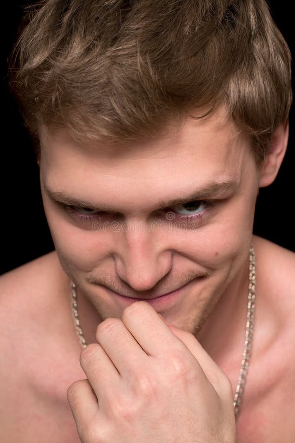 Young man with a malicious grin. Isolated on black. Negative moody stock images, royalty-free photos and pictures