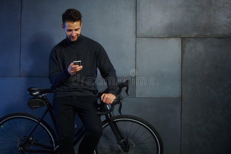 Young man with mobile and bicycle royalty free stock photography