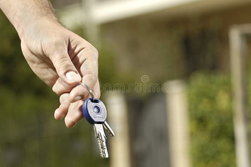 Young man and new home, door key in hand