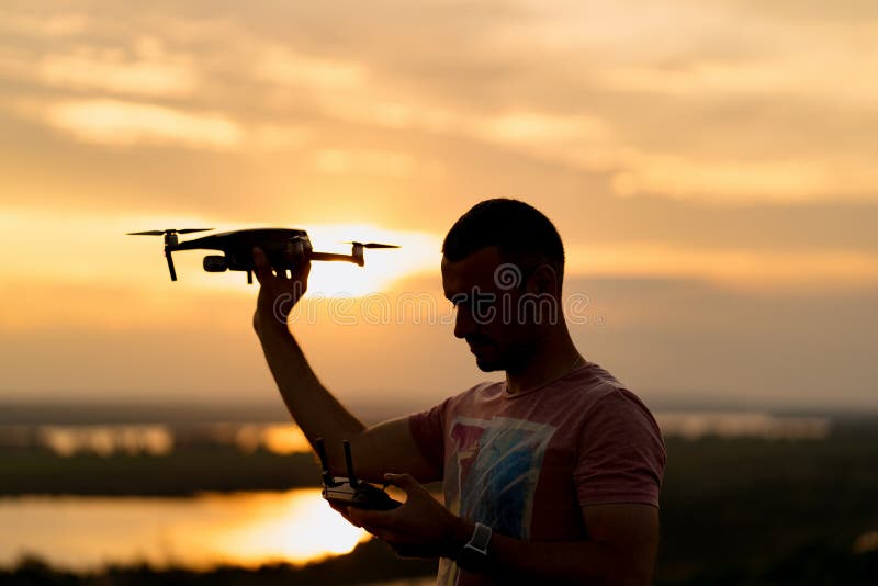 Young man piloting a drone in the evening