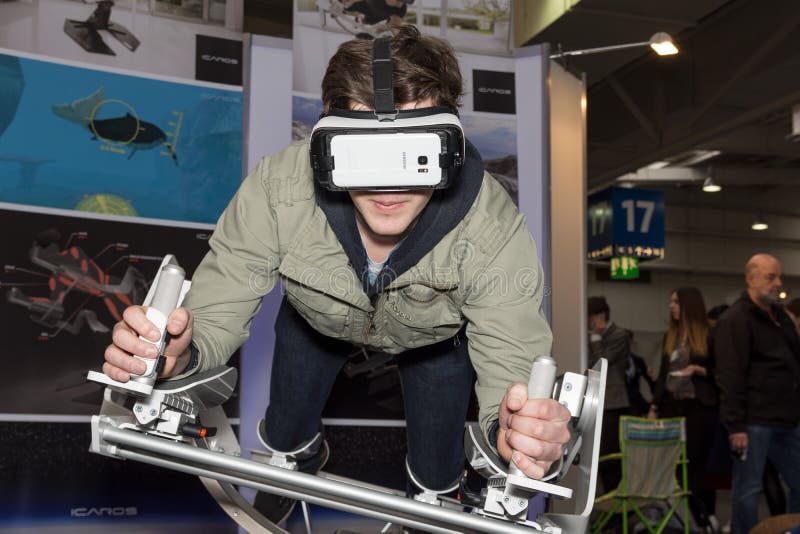 Hannover, Germany - March 22, 2017: A young man plays with a virtual reality flying, skydiving frame of the company Icaros at Cebit 2017. CeBIT is the world`s largest trade fair for information technology.