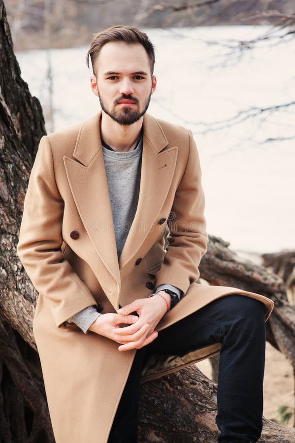 Young man portrait on the walk in autumn forest in beige coat royalty free stock images Young man portrait on the walk in autumn forest in beige coat royalty free stock images