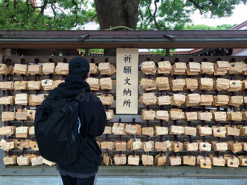 Young man praying with ema traditional wooden prayer board royalty free stock photos Young man praying with ema traditional wooden prayer board royalty free stock photos