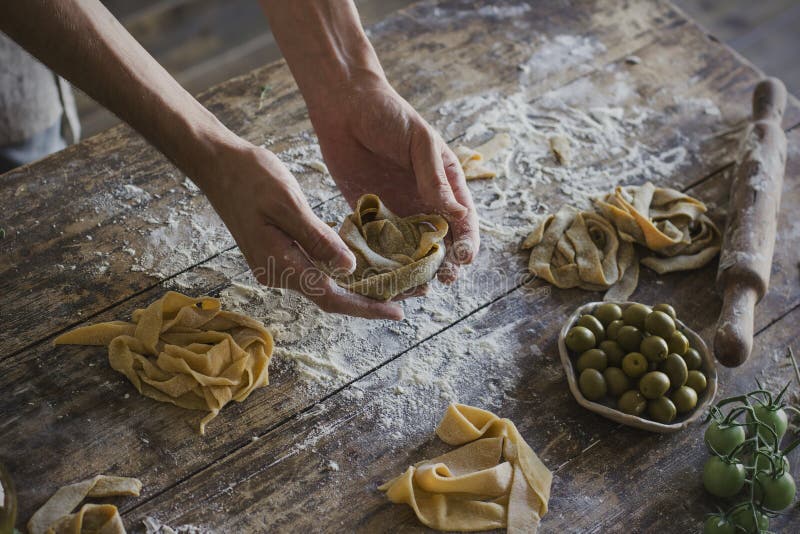 The young man prepares homemade pasta at rustic kitchen royalty free stock photography The young man prepares homemade pasta at rustic kitchen royalty free stock photography