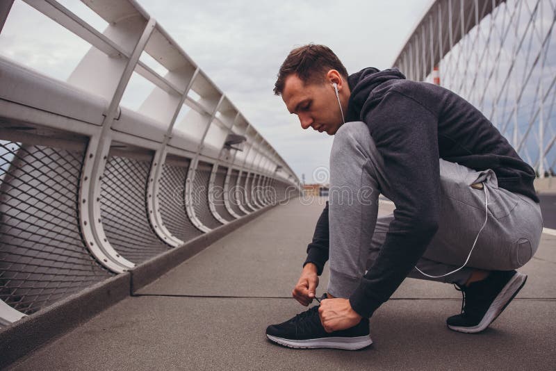 Young Man Preparing To Run in the City, Tying Jogging Shoes Stock Image ...