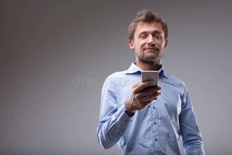 Young man reading a text message on his cellphone stock photography