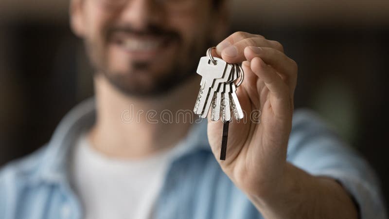 Young man realty buyer or seller holding keys in hand