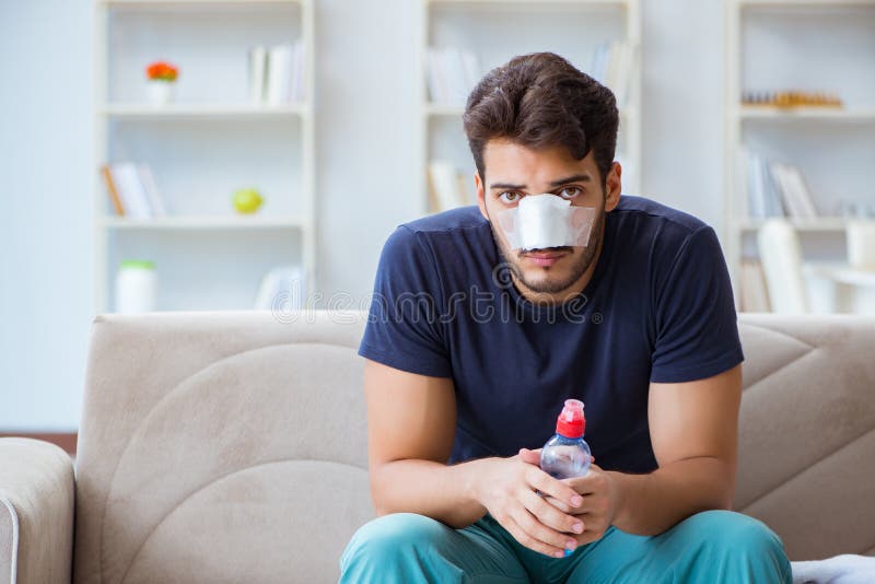 Young man recovering healing at home after plastic surgery nose stock image Young man recovering healing at home after plastic surgery nose stock image