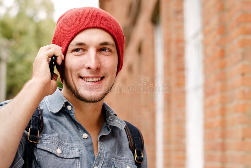 The young man with red cap calls on his cell phone