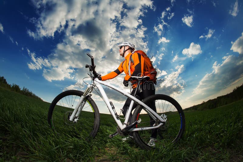 Young Man Riding on Bicycle through Deep Grass with Backpack Stock Photo Image of helmet
