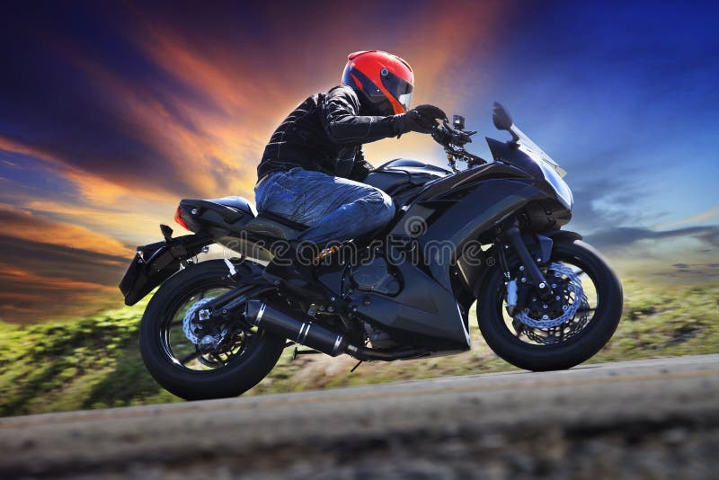 young man riding motorcycle on curve of asphalt country road against dusky sky use for sport activities,male leisure and journey royalty free stock photography young man riding motorcycle on curve of asphalt country road against dusky sky use for sport activities,male leisure and journey royalty free stock photography