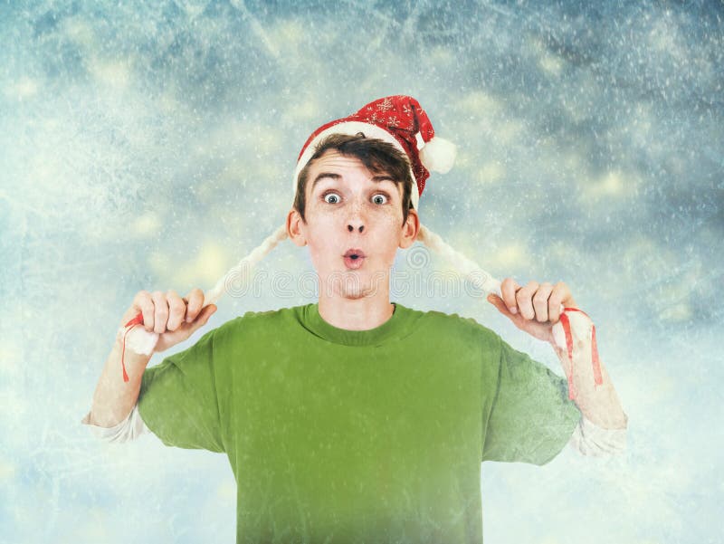 Young man in Santa hat on blue frozen background